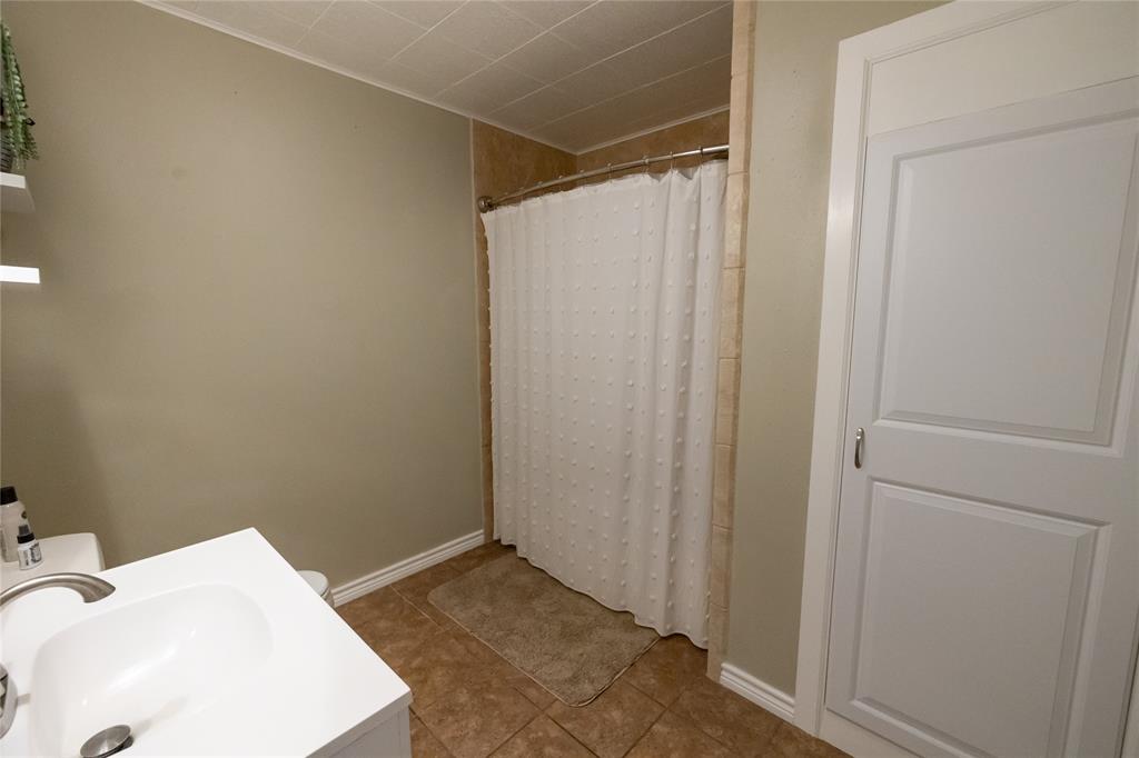 3205 42nd Street Snyder, TX 79549 - Photo 17 of 31 a bathroom with a sink and shower