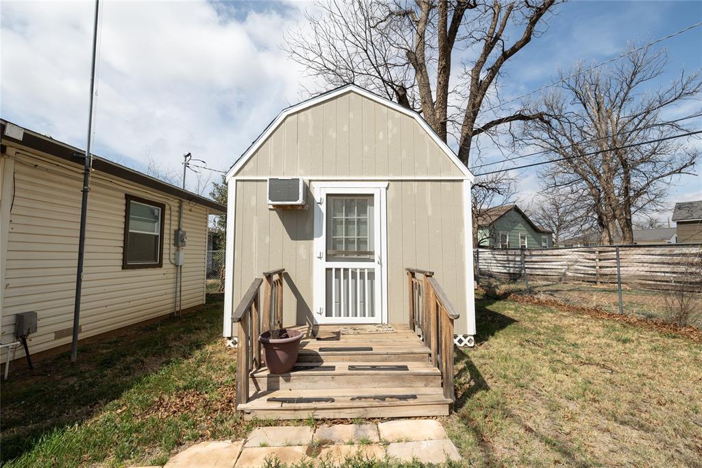 3205 42nd Street Snyder, TX 79549 - Photo 23 of 31 a view of a white house with a large tree bed and wooden fence