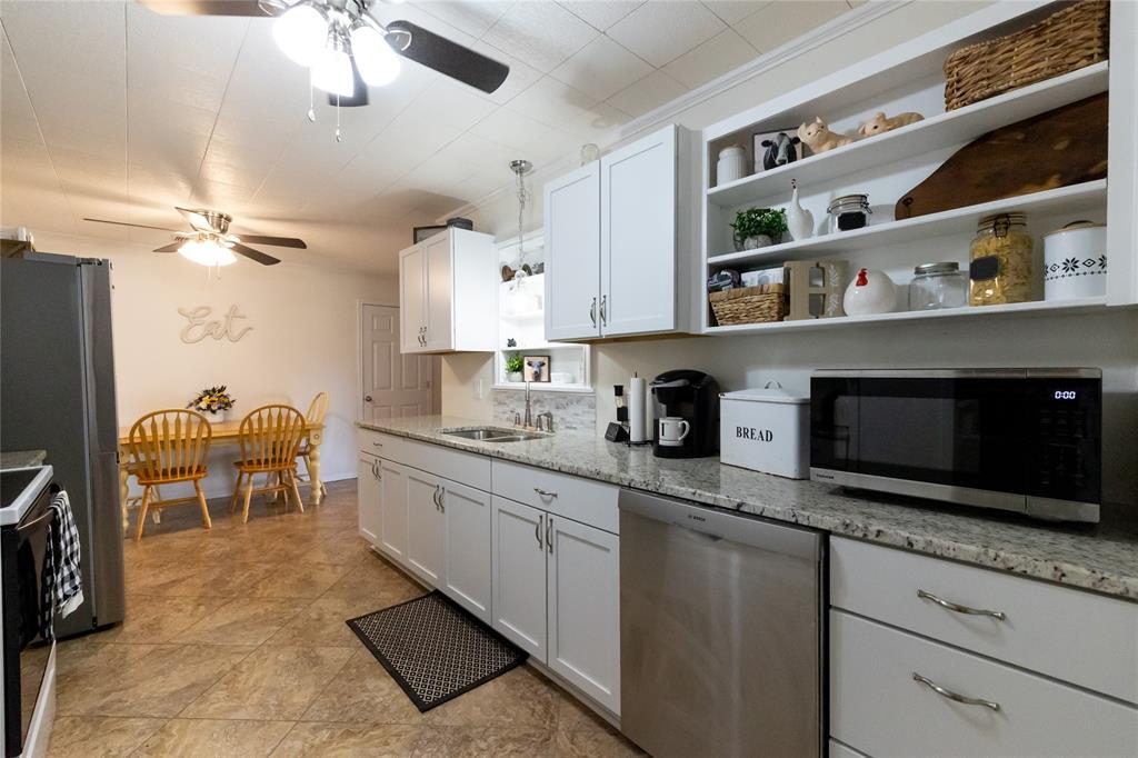 3205 42nd Street Snyder, TX 79549 - Photo 4 of 31 a kitchen with stainless steel appliances granite countertop a sink and cabinets