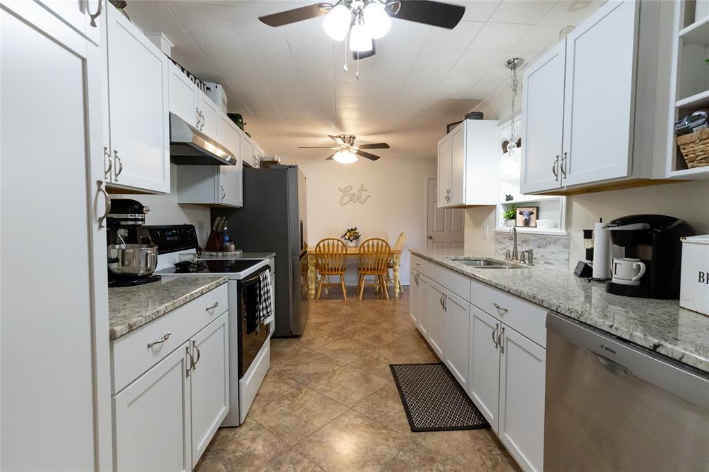 3205 42nd Street Snyder, TX 79549 - Photo 5 of 31 a kitchen with stainless steel appliances granite countertop a sink dishwasher stove and refrigerator