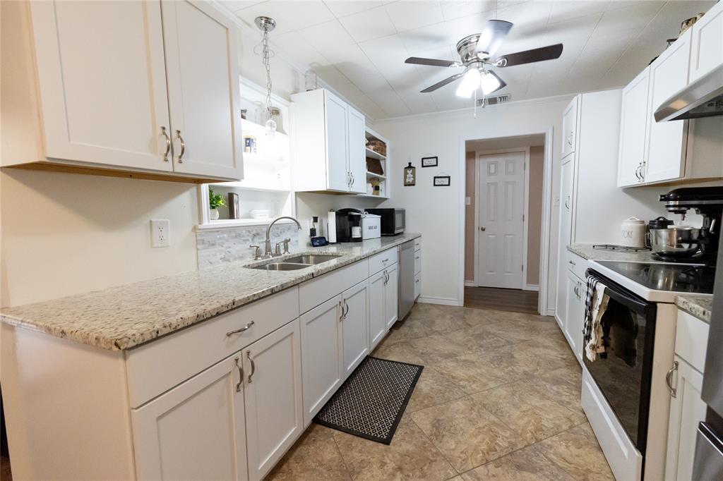 3205 42nd Street Snyder, TX 79549 - Photo 7 of 31 a kitchen with granite countertop a sink a counter space cabinets and stainless steel appliances