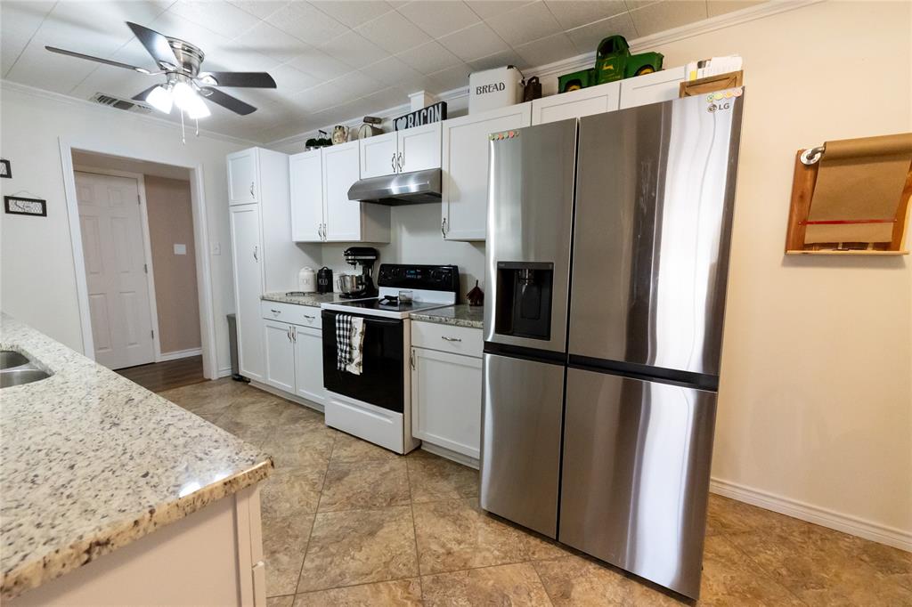 3205 42nd Street Snyder, TX 79549 - Photo 8 of 31 a kitchen with stainless steel appliances granite countertop a refrigerator a stove and a sink