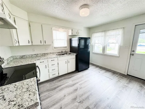 a kitchen with stainless steel appliances kitchen island granite countertop a sink cabinets and wooden floor