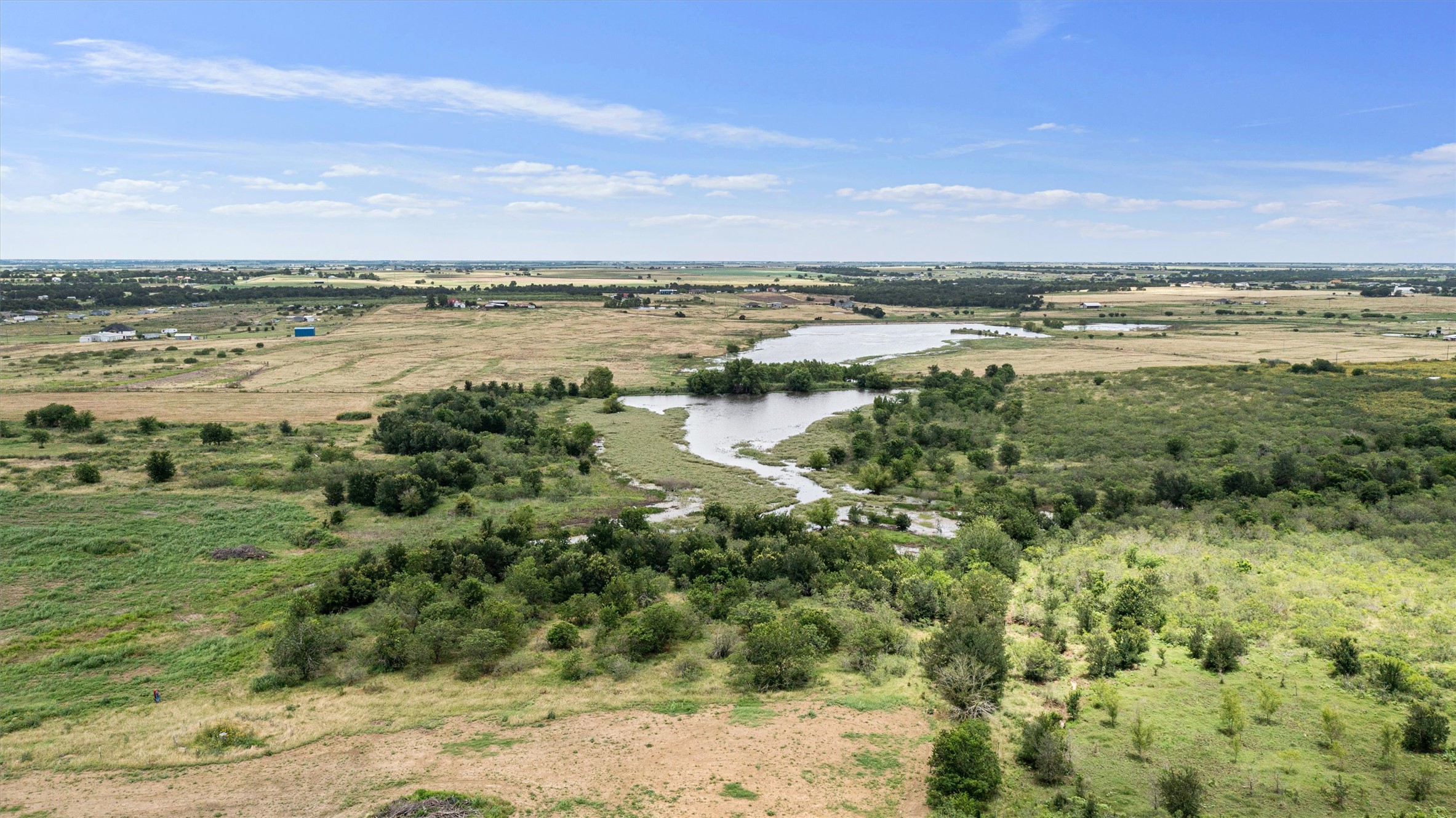 3315 County Road 463 Elgin, TX 78621 - Photo 13 of 32 Vast land with a winding pond and abundant greenery offers peaceful natural beauty.