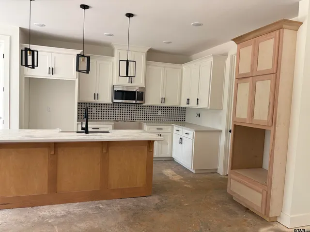 a kitchen with stainless steel appliances granite countertop a sink a stove and a refrigerator