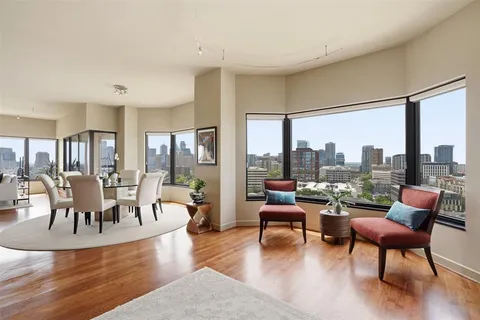 a dining room with wooden floor a glass table and chairs