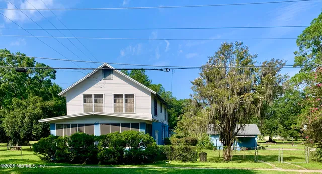 a front view of a house with a yard and trees