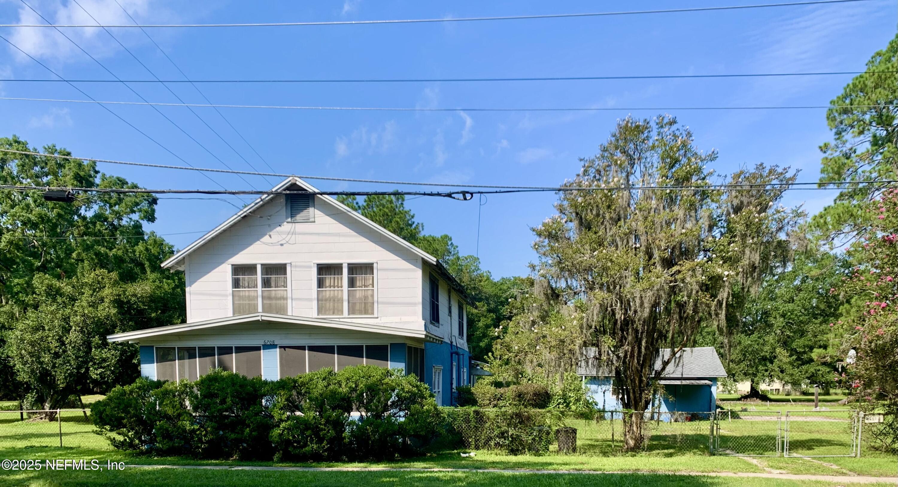 a front view of a house with a yard and trees