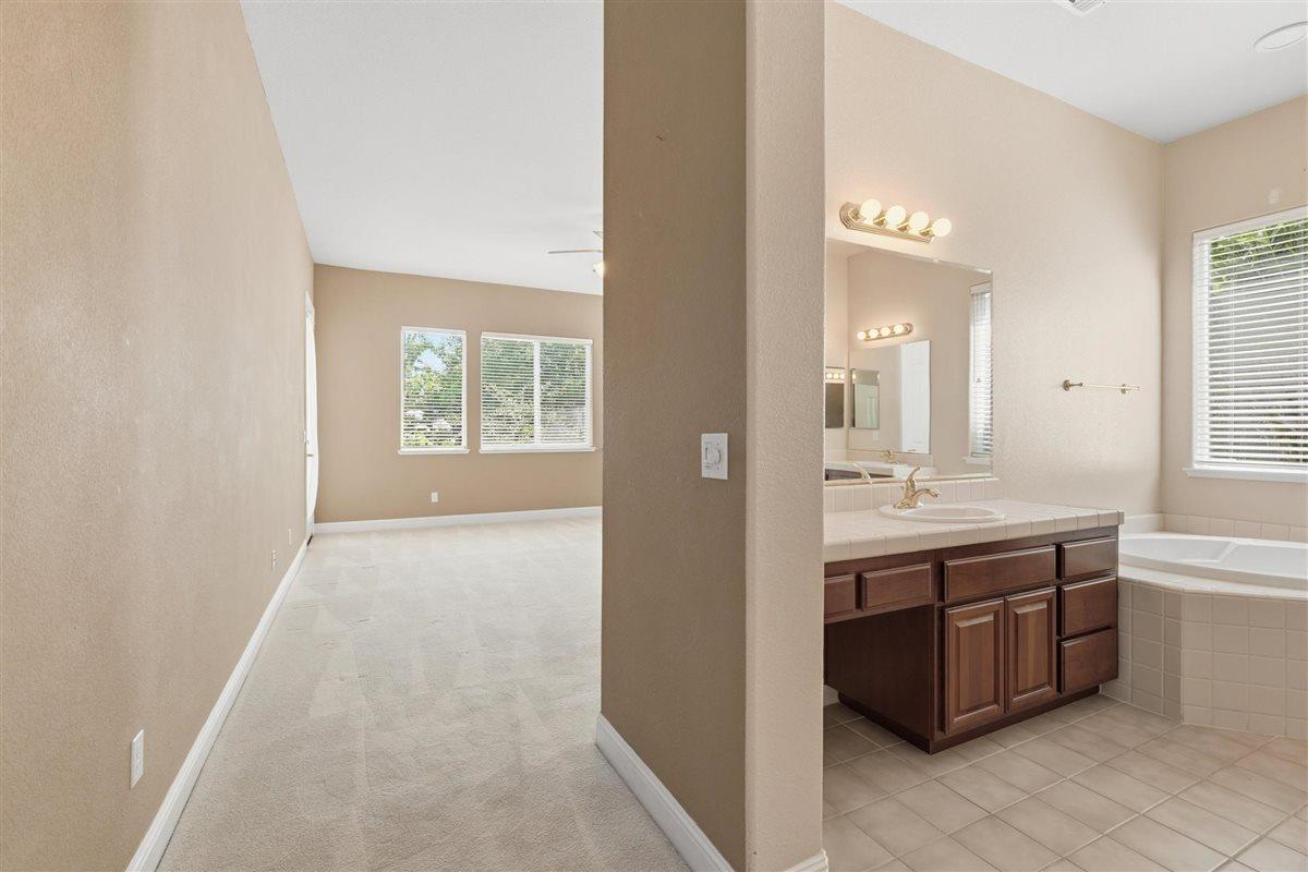 4129 Poppleton Way Carmichael, CA 95608 - Photo 26 of 48 a spacious bathroom with a granite countertop sink a mirror and a bathtub
