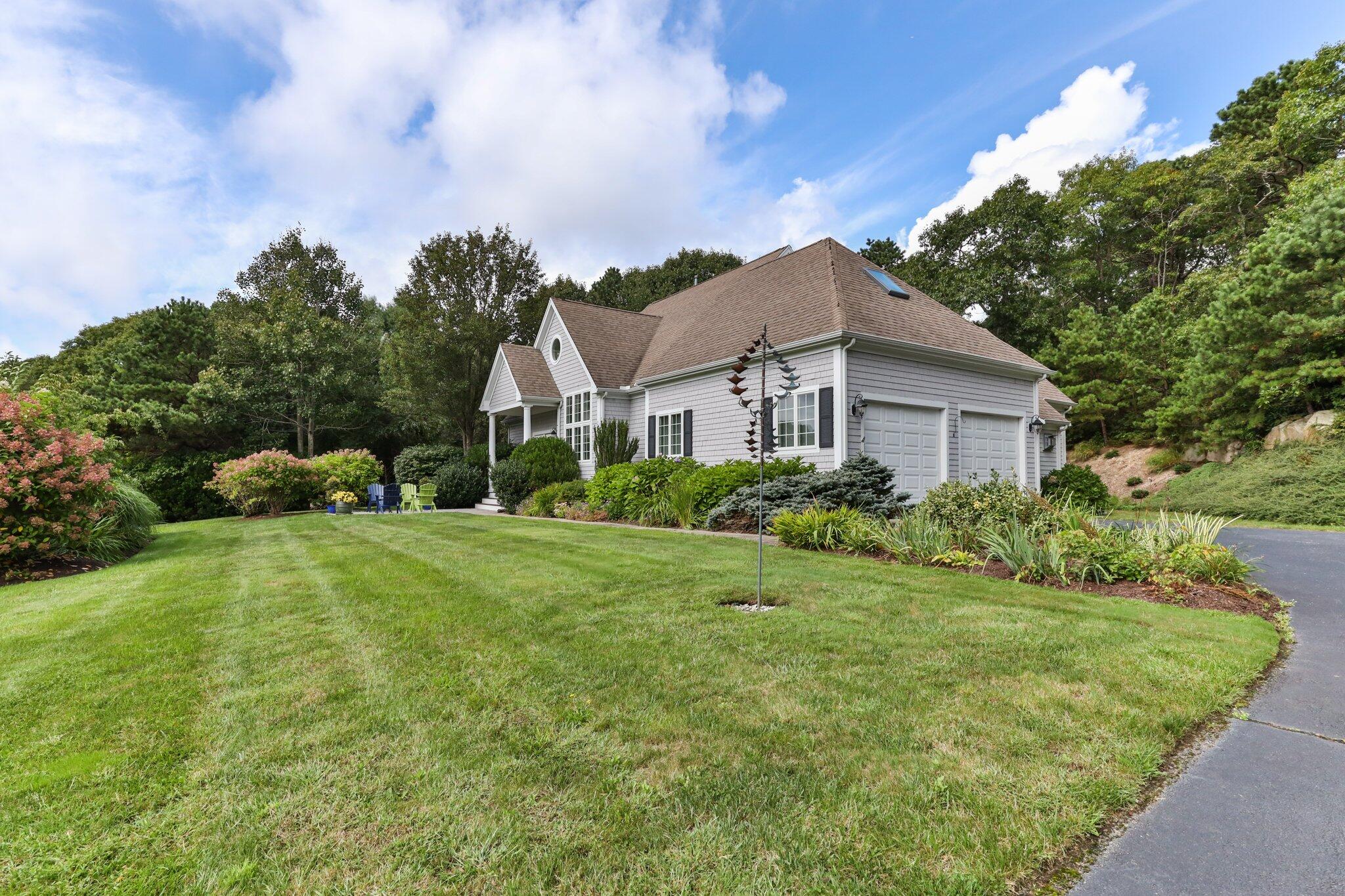 137 Cairn Ridge Road East Falmouth, MA 02536 - Photo 50 of 70 a view of a house with a big yard plants and large trees