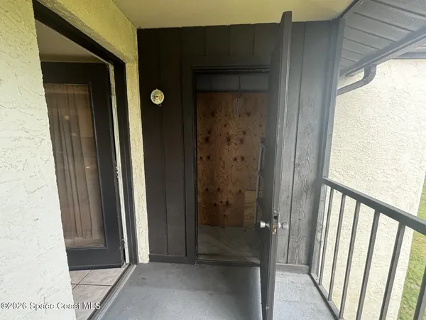 a view of a hallway with wooden floor and a bathroom