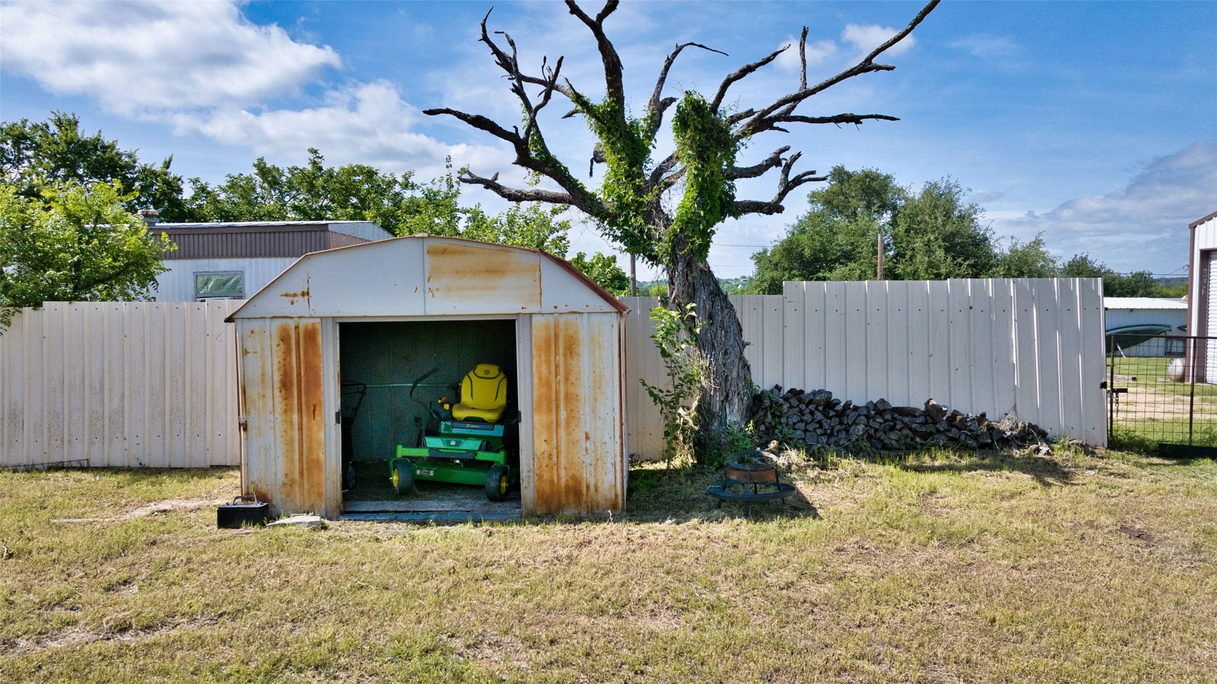 904 Bluebonnet Road Mason, TX 76856 - Photo 25 of 28 Corrugated metal shed with an open front and a metal fence enclosure