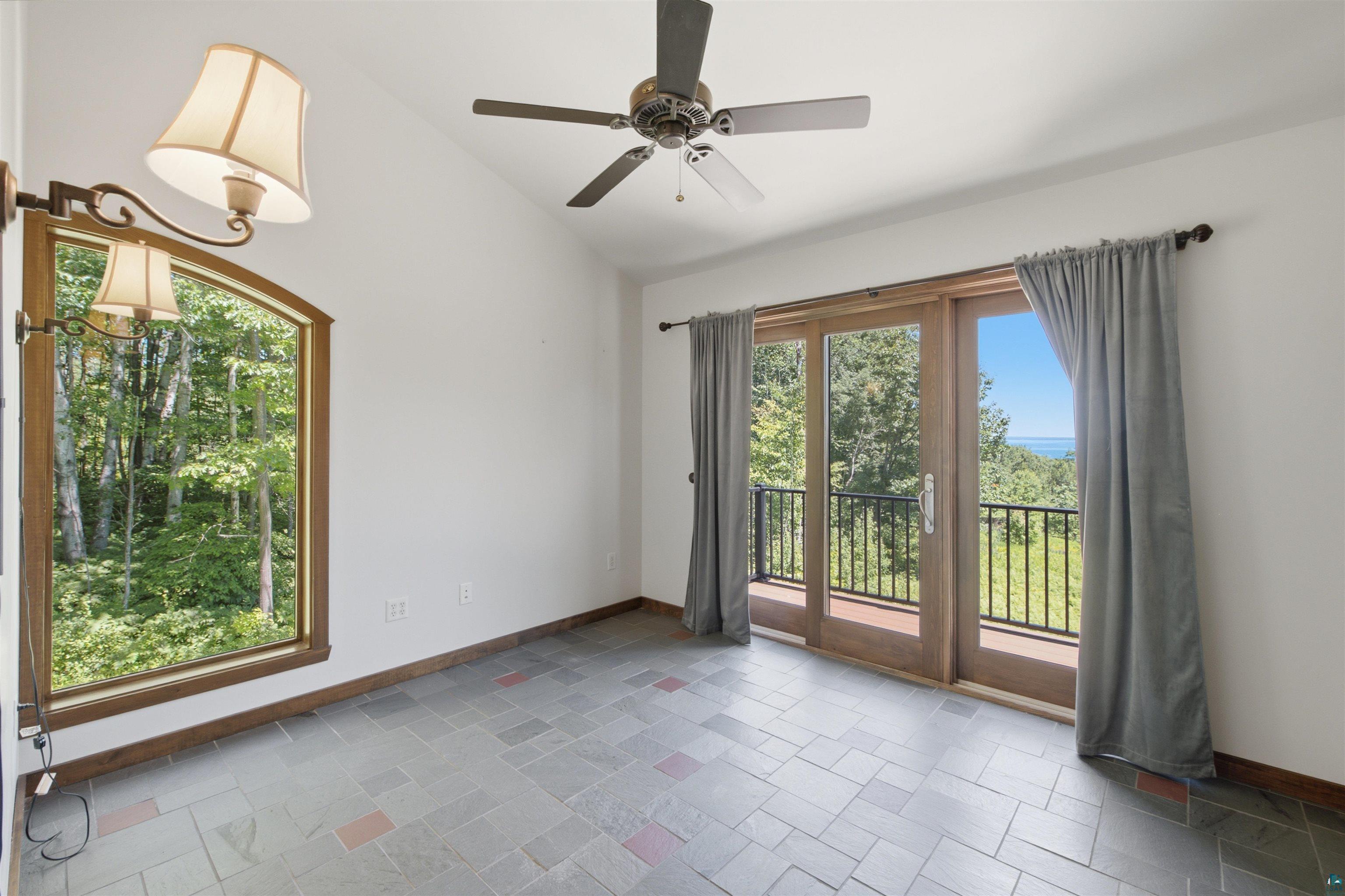 86270 Meyers-Olson Road Bayfield, WI 54814 - Photo 16 of 33 Spacious room featuring vaulted ceilings, a ceiling fan, and multi-tone tile flooring
