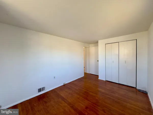 a view of a room with wooden floor and white walls