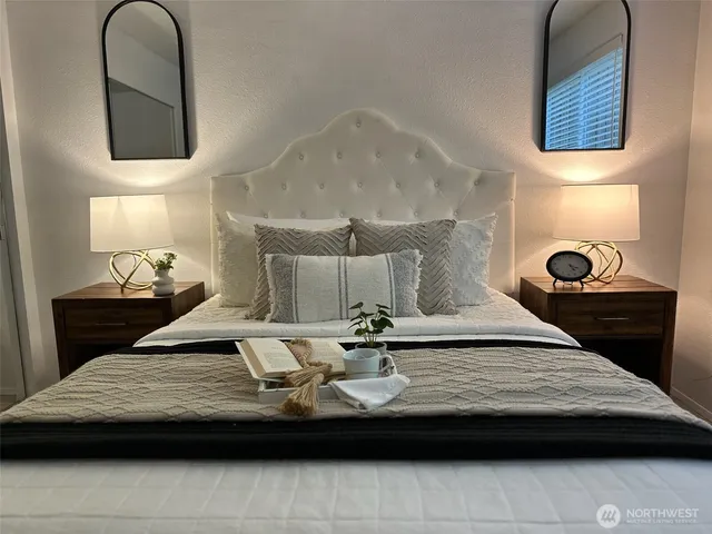 a bedroom with a bed and wooden floor