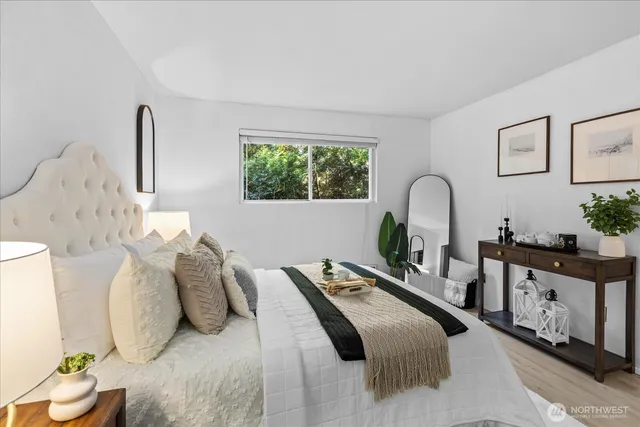 a view of a hallway with wooden floor and a bathroom