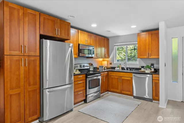 a kitchen with granite countertop stainless steel appliances a refrigerator sink and microwave