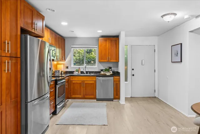 a kitchen with stainless steel appliances granite countertop a refrigerator and a sink