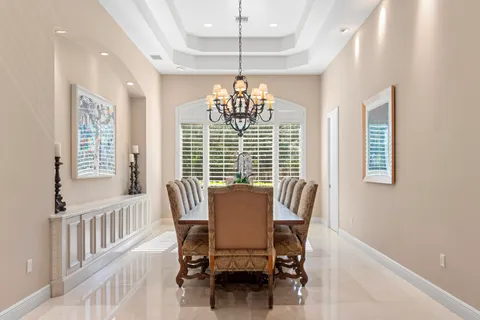 a kitchen with granite countertop white cabinets white appliances a sink and a large window