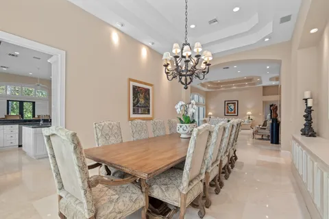 a dining room with furniture a large window and a chandelier