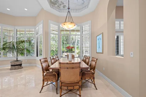 a living room with furniture kitchen view and large windows