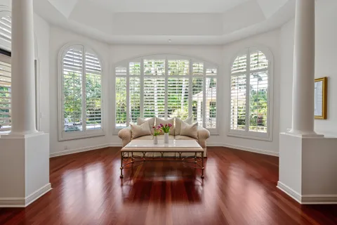 a spacious bedroom with a bed and wooden floor