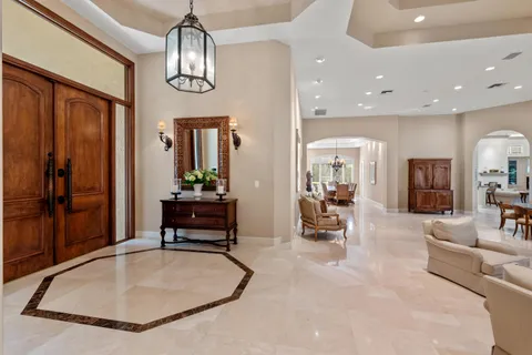 a living room with furniture chandelier and a large window
