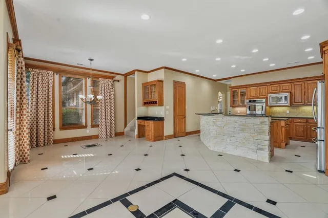 a view of kitchen with stainless steel appliances kitchen island sink and refrigerator