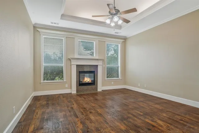 an empty room with windows fireplace and a sink