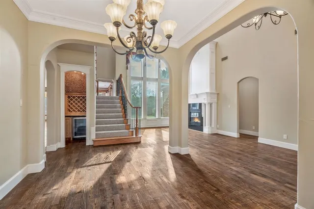 a view of a hallway with wooden floor and a chandelier