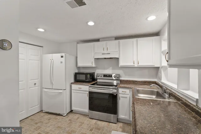 a kitchen with a stove sink and refrigerator