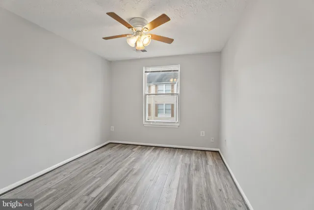an empty room with a window and wooden floor