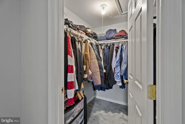 a view of walk in closet with clothes