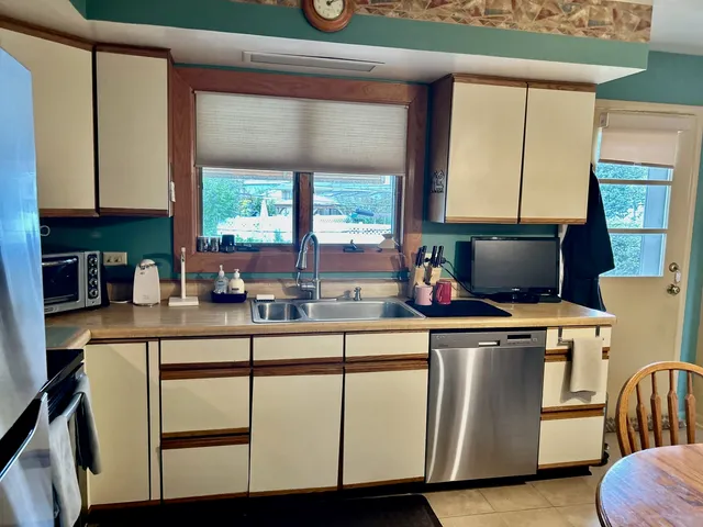 a kitchen with a sink a microwave a stove and cabinets