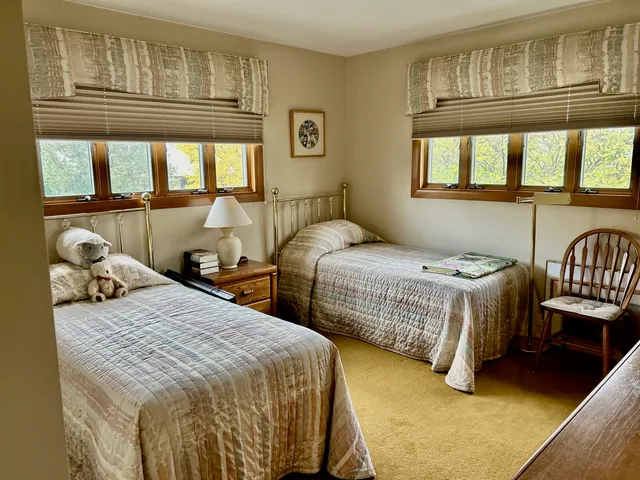 a bedroom with two beds and large window