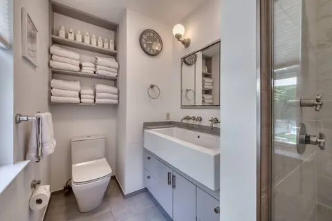 a bathroom with a toilet sink and mirror