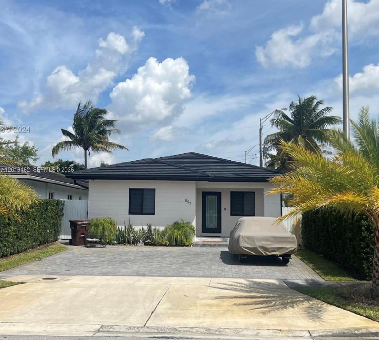 897 East 20th Street Hialeah, FL 33013 - Photo 1 of 13 a white house with a yard plants and palm trees