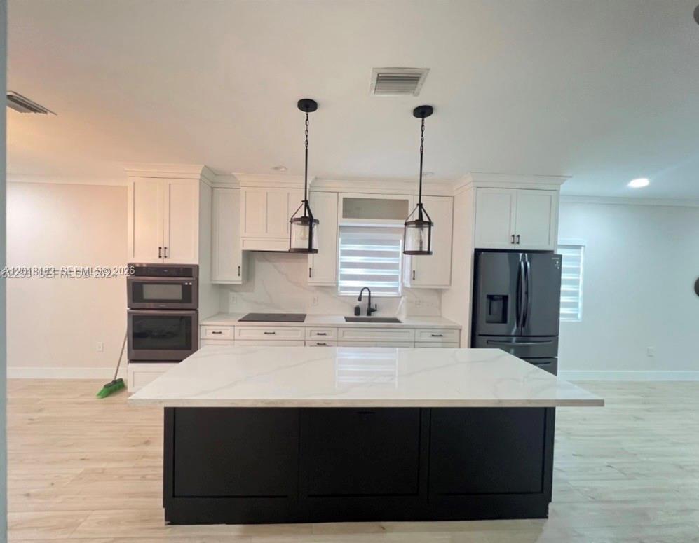 897 East 20th Street Hialeah, FL 33013 - Photo 3 of 13 a kitchen with stainless steel appliances a sink stove and refrigerator