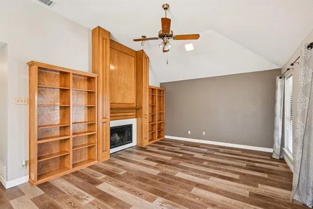 a view of an empty room with a fireplace and a window