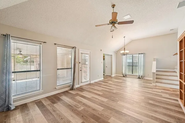 a view of a livingroom with wooden floor and a ceiling fan