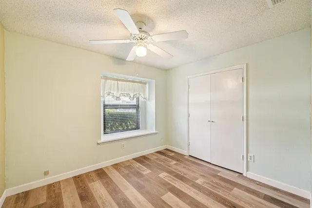 an empty room with a window and wooden floor