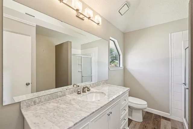 a bathroom with a granite countertop sink toilet and shower