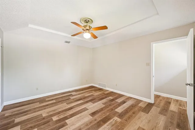 a view of a room with a hanging light and wooden floor