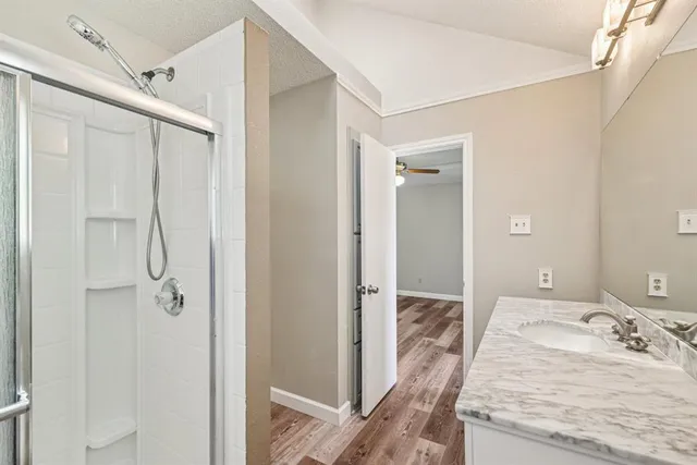 a en suite bathroom with a granite countertop sink mirror and shower