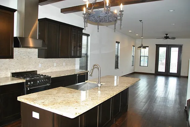 a kitchen with stainless steel appliances granite countertop a sink stove and cabinets