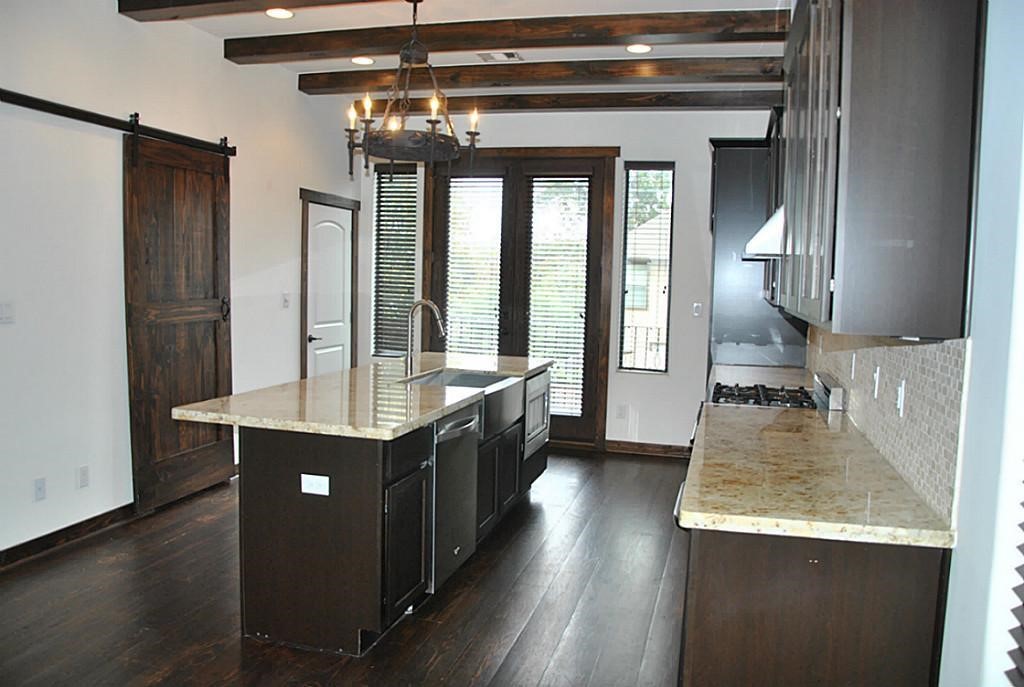 5312 Inker Street, Unit A Houston, TX 77007 - Photo 3 of 10 a kitchen with kitchen island a counter top space a sink stainless steel appliances and cabinets