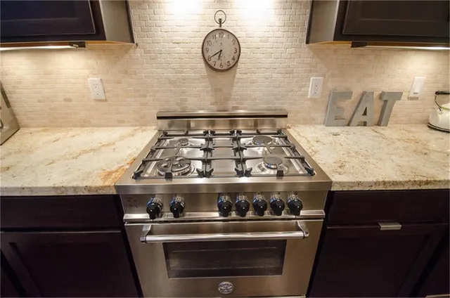 a stove top oven sitting inside of a kitchen