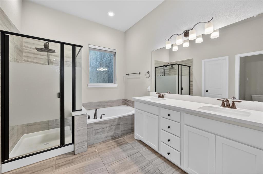 4224 Riverside Drive Flower Mound, TX 75028 - Photo 16 of 23 a spacious bathroom with a double vanity sink a mirror a window and a bathtub