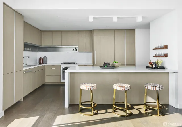 a room with table chairs cabinets and stainless steel appliances