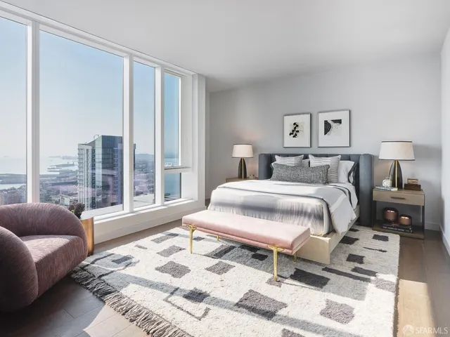 a bedroom with a bed and a couch next to a window